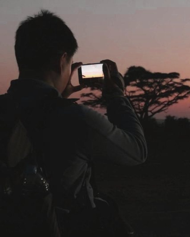 A guest shooting the grassland sunset on a phone